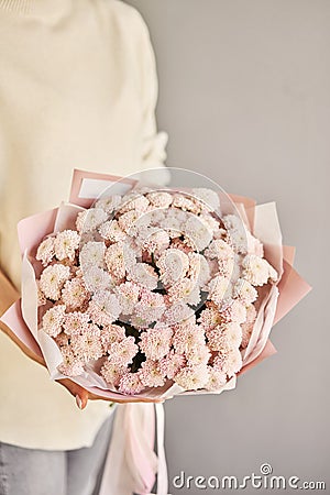 a beautiful mono bouquet of fresh flowers in the hands of a florist. A gift bouquet for any holiday. A very nice female Stock Photo