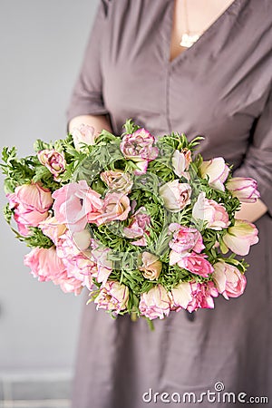 Beautiful bouquet of pink anemones in woman hand. the work of the florist at a flower shop. A small family business Stock Photo