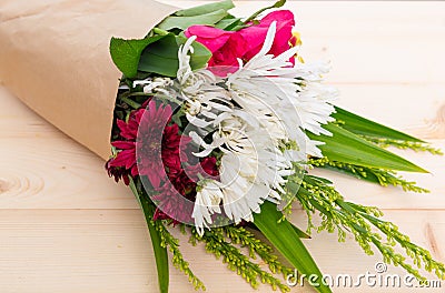 Beautiful bouquet with pink roses,white carnation,red chrysanthemum on natural wood background Stock Photo