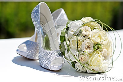 Beautiful bouquet of roses and wedding shoes Stock Photo