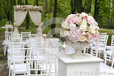 Beautiful bouquet in stone vase in front of wedding arch Stock Photo
