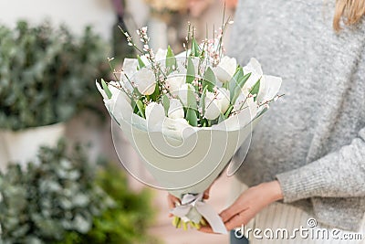 Beautiful bouquet of white tulips flowers in woman hand. the work of the florist at a flower shop. cute lovely girl Stock Photo