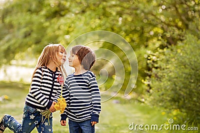 Beautiful boy and girl in a park, boy giving flowers to the girl Stock Photo