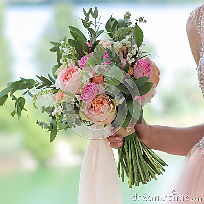 Beautiful bridal bouquet in hands of the bride. Wedding bouquet of peach roses by David Austin, single-head pink rose aqua, Stock Photo