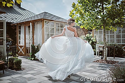 Beautiful bride running away in the garden Stock Photo