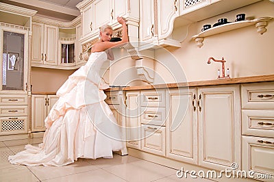 Beautiful bride stands in the kitchen Stock Photo
