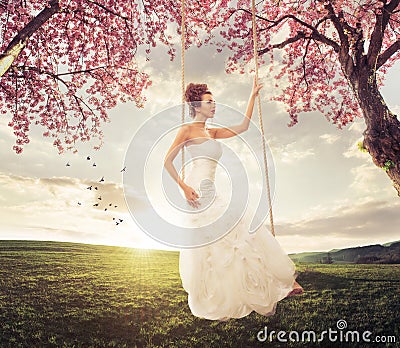 Beautiful Bride swing in the spring meadow Stock Photo