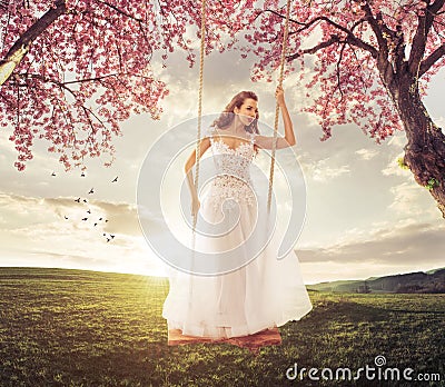 Beautiful Bride swing in the spring meadow Stock Photo