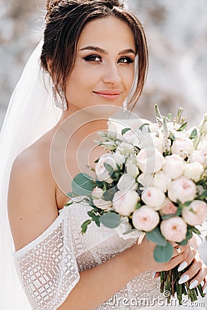 Beautiful bride in a wedding dress with a bouquet on the top of the salt mountains. A stunning young bride with curly hair . Stock Photo