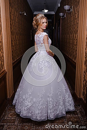 Beautiful bride in a wedding dress in white interior Stock Photo