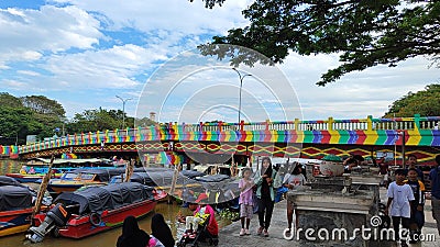 Beautiful bridge with rainbow colored paint over the Martapura river with boats anchored in the city of Banjarmasin Editorial Stock Photo