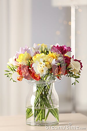 Beautiful bright spring freesia flowers in vase on table. Stock Photo