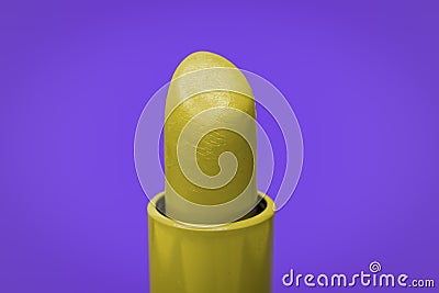 Beautiful bright yellow lipstick and purple complementary color on the background Stock Photo