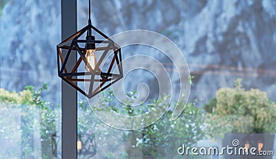 Beautiful brown chandelier in a cafe on the background of bushes Stock Photo