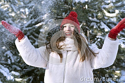 Beautiful brunette girl in red hat with bubo throws snow. Little red riding hood Stock Photo