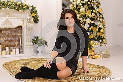 Beautiful brunette girl smiles and posing while sitting on backg Stock Photo