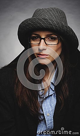 Beautiful brunette with hat and glasses posing in studio in various positions and industry-specific representations photo stock. Stock Photo