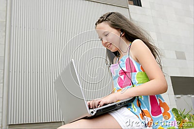 Beautiful brunette teen little girl laptop city Stock Photo