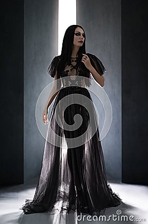 Beautiful brunette woman with gothic makeup wearing stylish black dress Stock Photo