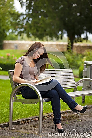 Beautiful brunette woman reading a book Stock Photo