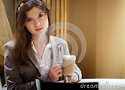 Beautiful brunette woman in restaurant drinking coffee Stock Photo