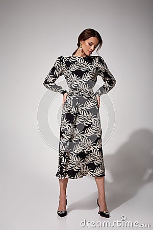 Beautiful brunette woman tanned skin glamour model pose wear fashion clothes midi long silk dress style for date party meeting Stock Photo