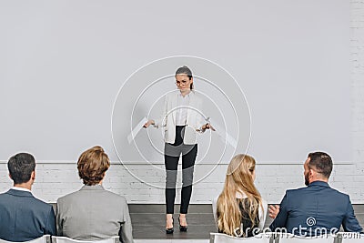 beautiful business coach standing on stage and gesturing during training Stock Photo