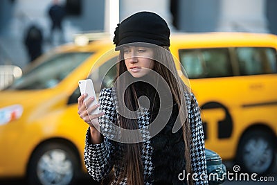 Beautiful business woman calling taxi using mobile phone in the city street Stock Photo