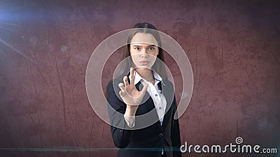 Beautiful business woman is pushing an invisible button, gray background Stock Photo