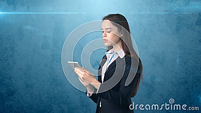 Beautiful businesswoman is looking into a touch pad, blue background Stock Photo