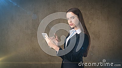 Beautiful businesswoman is looking into a touch pad, brown background Stock Photo