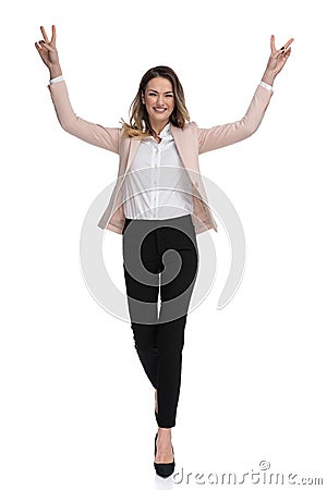 Beautiful businesswoman walks and celebrates with hands in the air Stock Photo