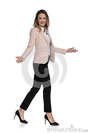 Beautiful businesswoman walks to side and makes inviting gesture Stock Photo