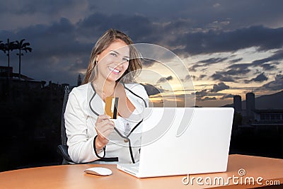 Beautiful Bussiness Woman smiling with her credit in the computer