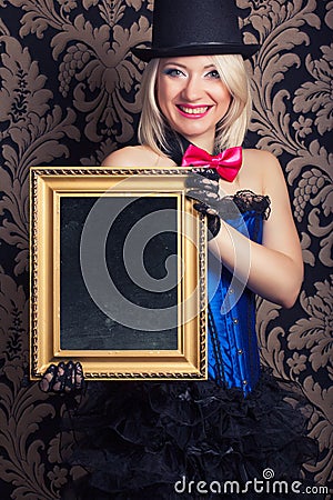 Beautiful cabaret woman posing with golden frame against retro w Stock Photo