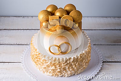 Beautiful cake for the 50th anniversary of the wedding decorated with gold balls and rings. Concept of festive desserts Stock Photo