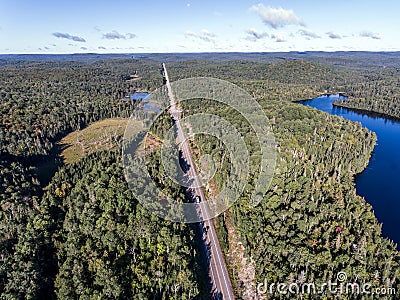 Beautiful Canada camper bus driving on road endless pine tree forest with lakes moor land aerial view travel background Stock Photo