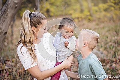 Beautiful candid portrait of a mother playing with her cute bi-racial sons Stock Photo