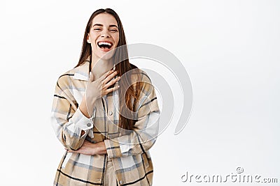 Beautiful candid woman laughing naturally, hear funny joke, touching chest while chuckle and having fun, watching comedy Stock Photo