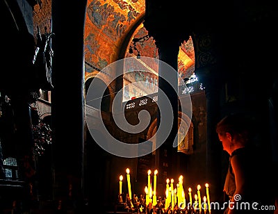 Unidentified girl with lit candles in Basilica in Venice Editorial Stock Photo