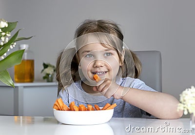 Beautiful caucasian girl eating carrots. Kid's healthy nutrition concept. Little child eating fresh vegetables Stock Photo