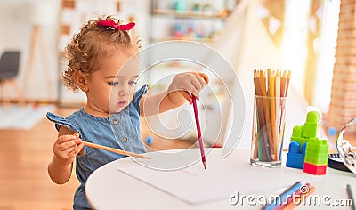 Beautiful caucasian infant playing with toys at colorful playroom Stock Photo