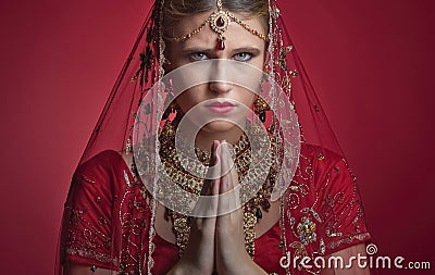 Beautiful caucasian woman dressed in Indian bridal Sari along with specific jewelry: Mangalsutra, Thaali, Maang Tikka, Choora, Nat Stock Photo