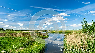 Beautiful polder landscape with the reflections of the sky in a wide ditch, near Rotterdam, the Netherlands Stock Photo
