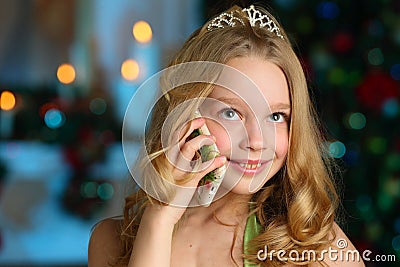 Beautiful charming pretty blond child-girl on the background of a New Year tree Stock Photo