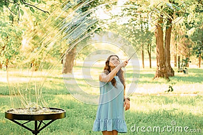 Beautiful cheerful girl stands in the park and inflates soap bubbles Stock Photo