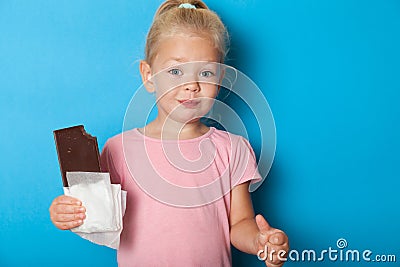 Beautiful child girl eat bite chocolate, happy face. Messy fun Stock Photo