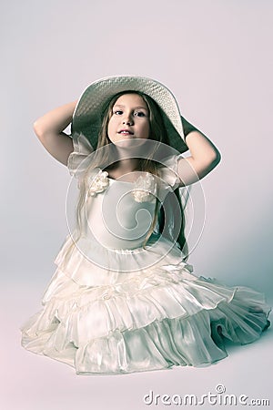 Beautiful child girl in elegant dress and hat. Stock Photo
