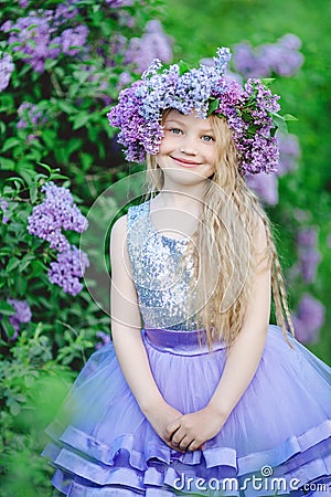 Beautiful child girl with wreath of lilac flowers Stock Photo