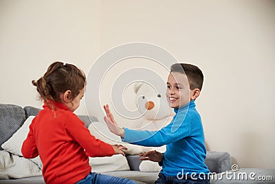 Happy boy and girl claping their hands while playing together Stock Photo